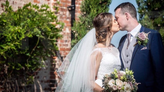 Ashley and Jason kissing on their wedding day outdoors, before beginning their fertility journey with Care Fertility Sheffield.