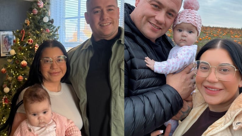 Elle-may and Tony standing together with their baby daughter Delilah Rose, smiling at the camera, in a family photo at home and outdoors.