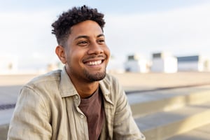 Man of colour looking happy and smiling with a landscape in the background