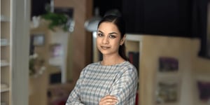 Young asian woman with her arms crossed and smiling towards the camera.