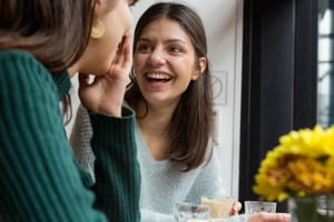 Two women sat having a conversation over coffee