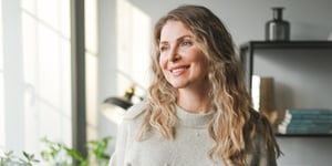 Blonde wavy-haired woman smiling, looking ahead