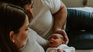 Reka and Jerry holding their newborn daughter, Nora Sofia, at home after her birth following IVF treatment.