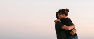 Man and woman hugging in front of sunset-1