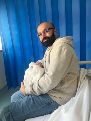 Mobeen holding his newborn daughter in hospital after IVF treatment at Care Fertility.
